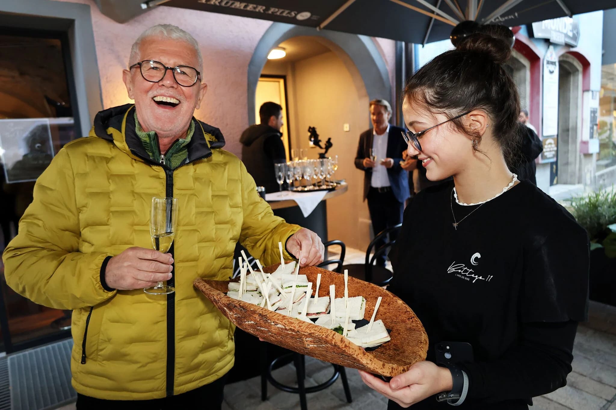 Gäste mit Sekt und Tramezzini vor der Bottega 11 bei der Eröffnung